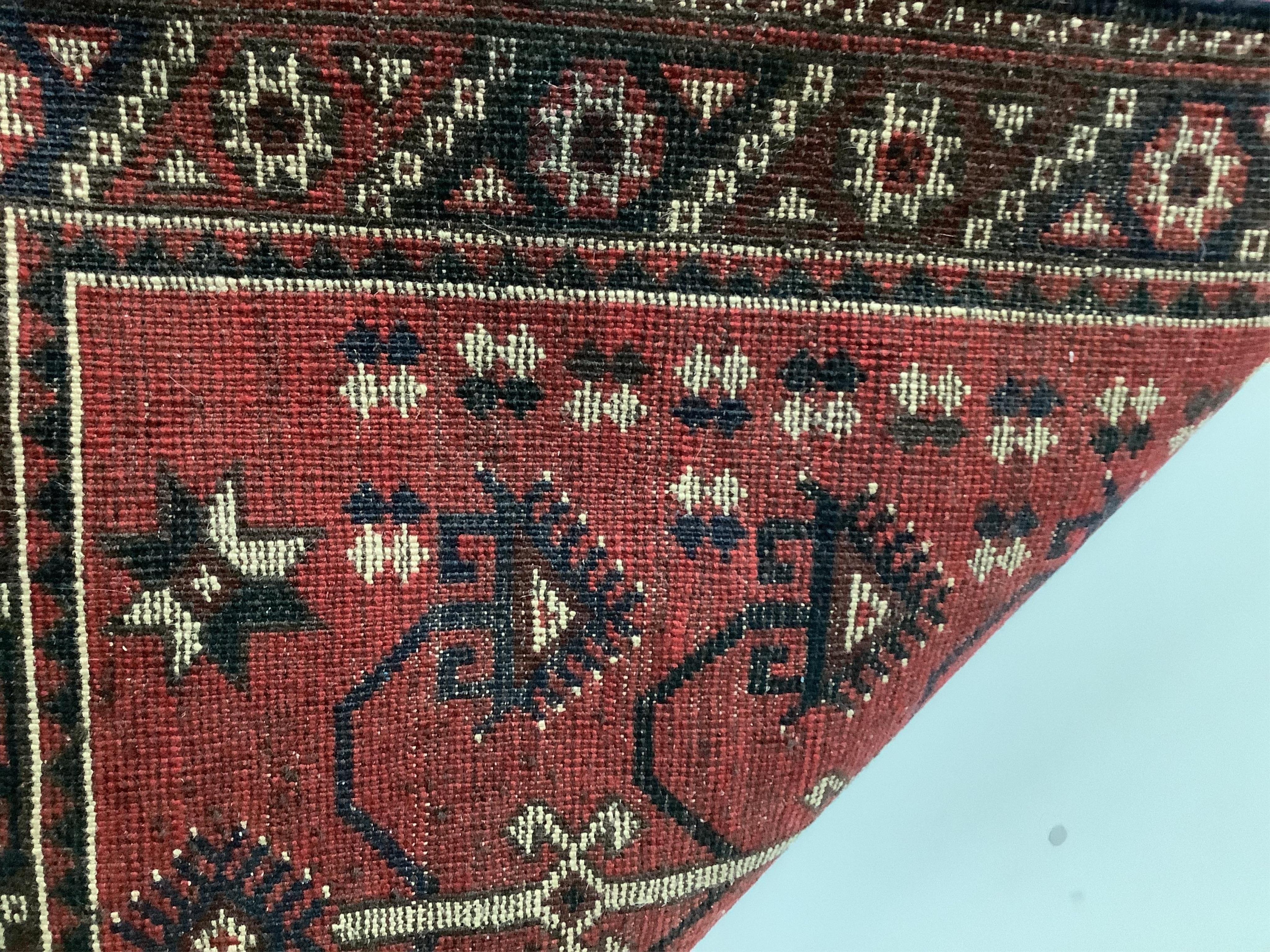 A Kazak style red ground rug, (moth damage) and a Turkish red ground rug, larger 200 x 98cm. Condition - poor to good